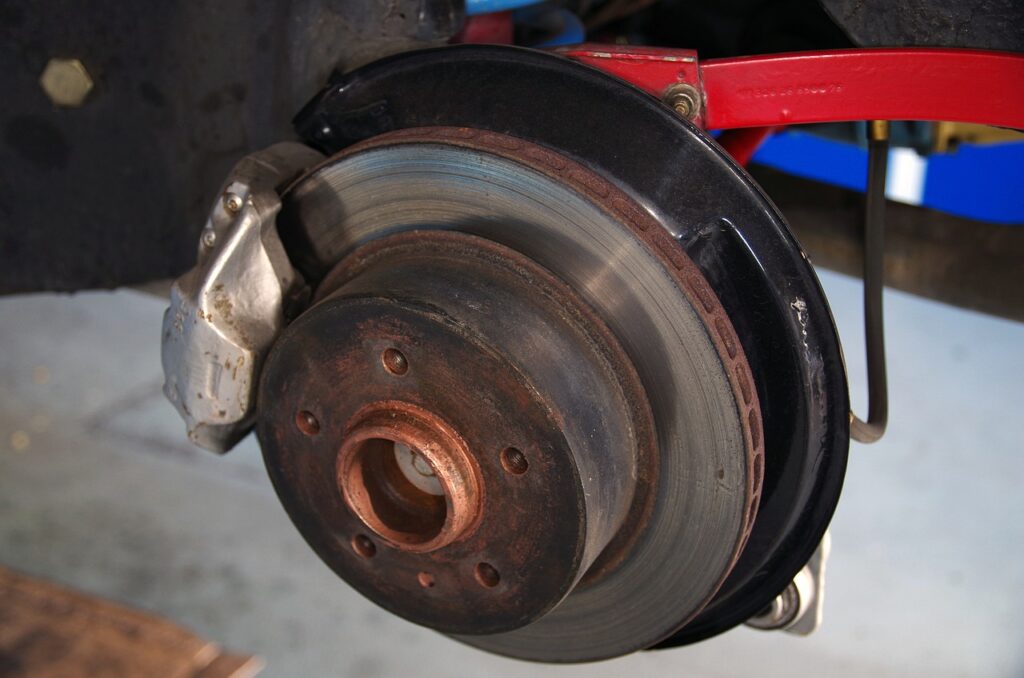 Close-up of a car brake disc and caliper on a lifted vehicle, a safety part often targeted by counterfeiters in Kenya