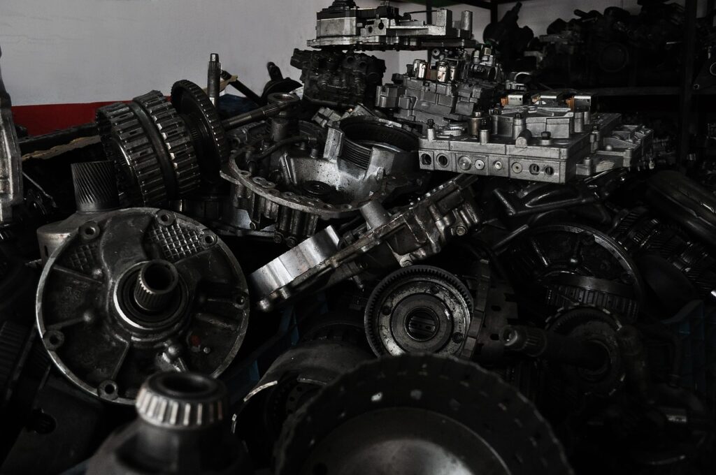 Assorted used car spare parts including gearbox components and gears, illustrating how to tell genuine from fake spare parts in Kenya